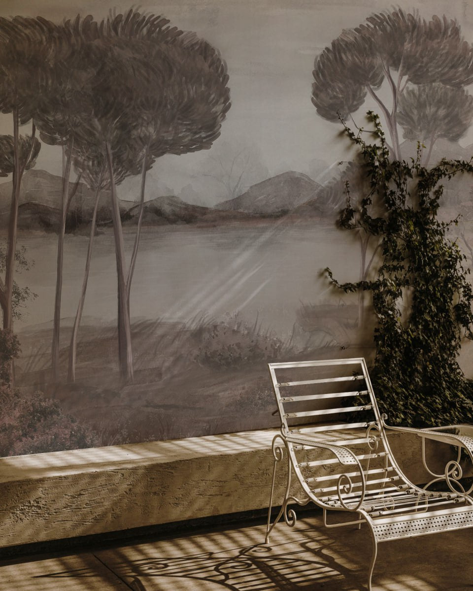 Outdoor setting with a bench and chair against a scenic wall mural.