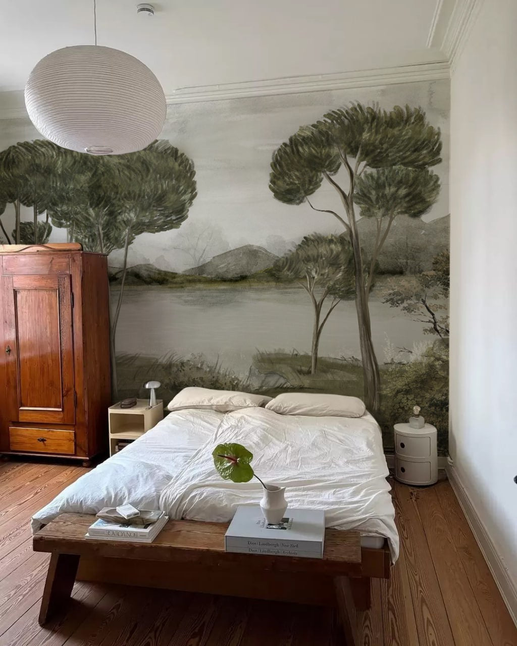 Bedroom with mural of trees and landscape on the wall
