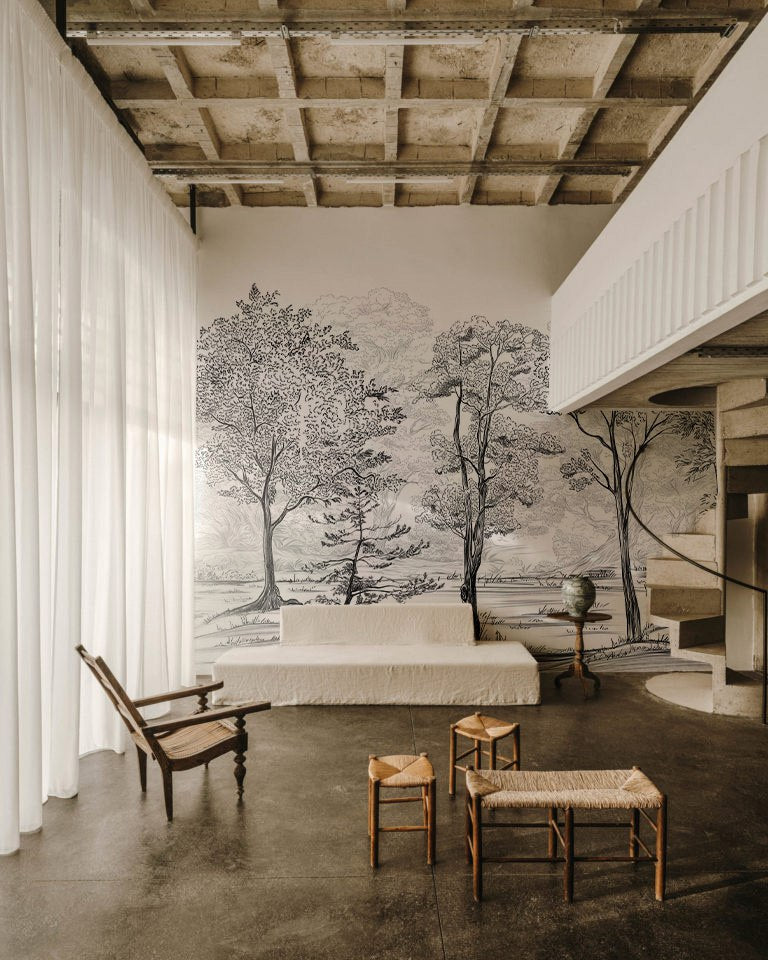 Modern interior with a large wall mural of trees, white sofa, and wooden furniture.
