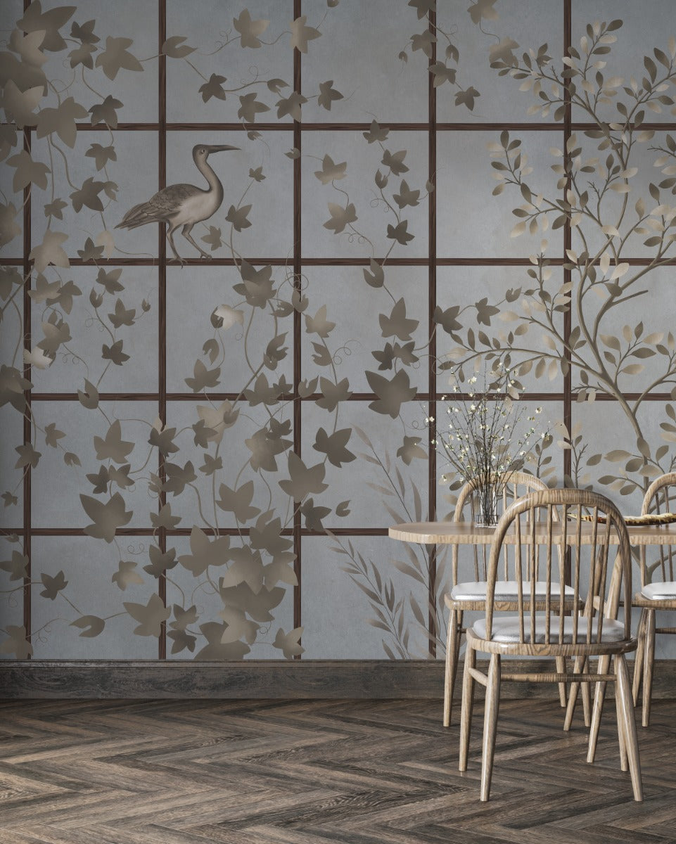 Dining area with wooden chairs and a table against a decorative wallpaper with floral & chinoiserie patterns.