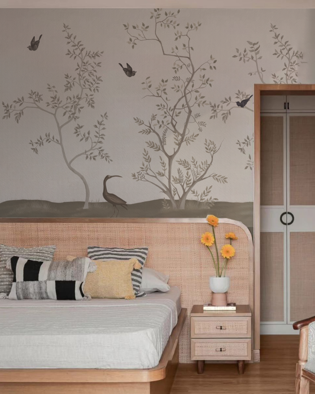 Bedroom with wooden bed, nightstand, and chair, featuring an India in the Wilde wallpaper and decor.