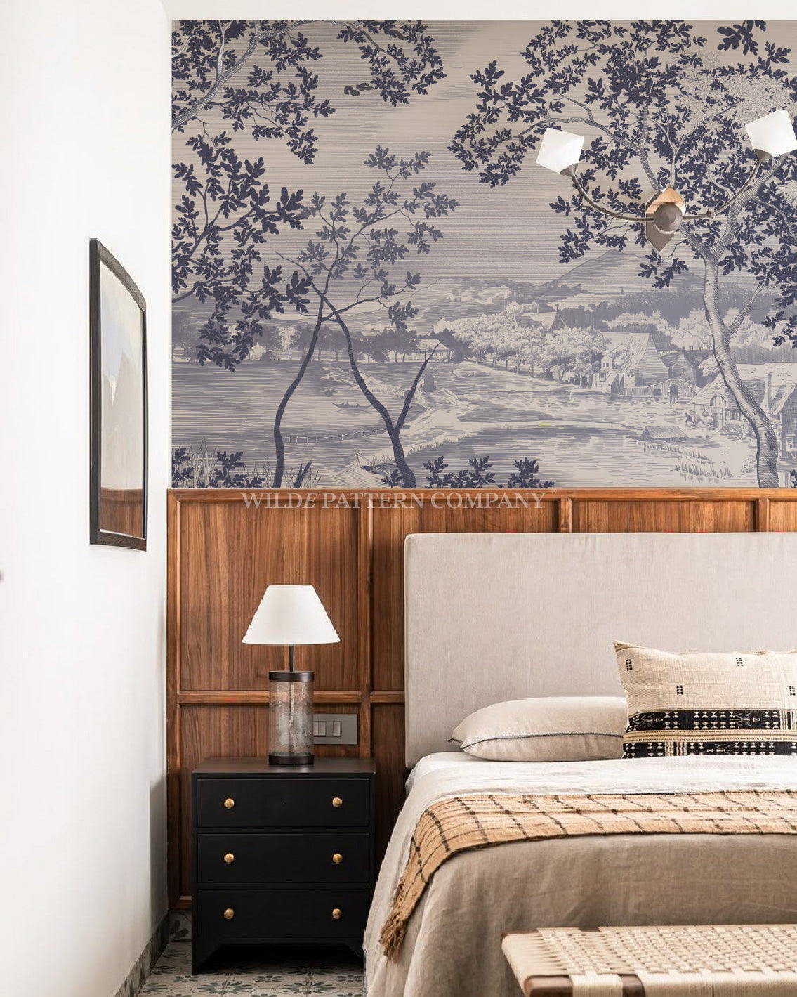 Modern bedroom with toile indigo wallpaper, wooden headboard, and nightstand.