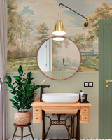Bathroom with round mirror, sink, and decorative wall mural